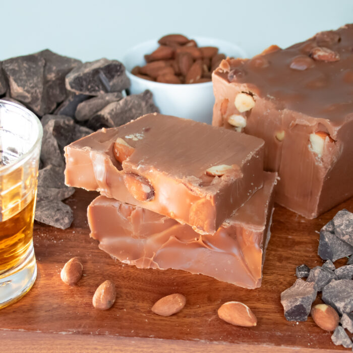 Smoked Whiskey Fudge, Experience the bold flavor of our Smoked Whiskey Fudge. We infused our creamy Belgian chocolate fudge with whiskey flavor and crunchy smoked almonds to make for the perfect balance of sweetness, smokiness, and texture. This non-alcoholic treat delivers a well-rounded flavor that goes well with a cola, fruit, or classic whiskey pairing. Enjoy responsibly!